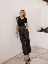 a lady in a black seamless asymmetric neck knit top